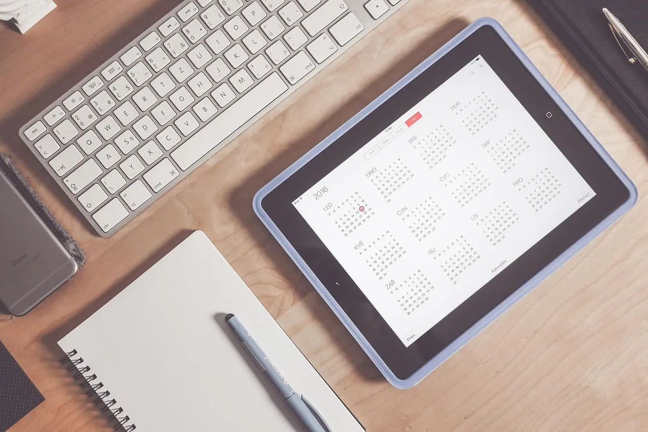 Photo showing calendar, desk, tablet and device.