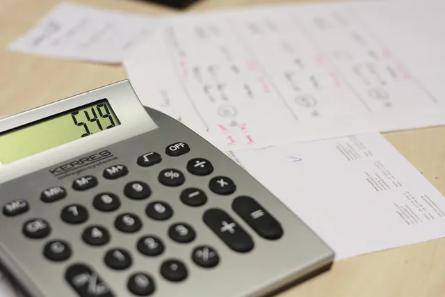 Photo showing calculator, table and invoice.