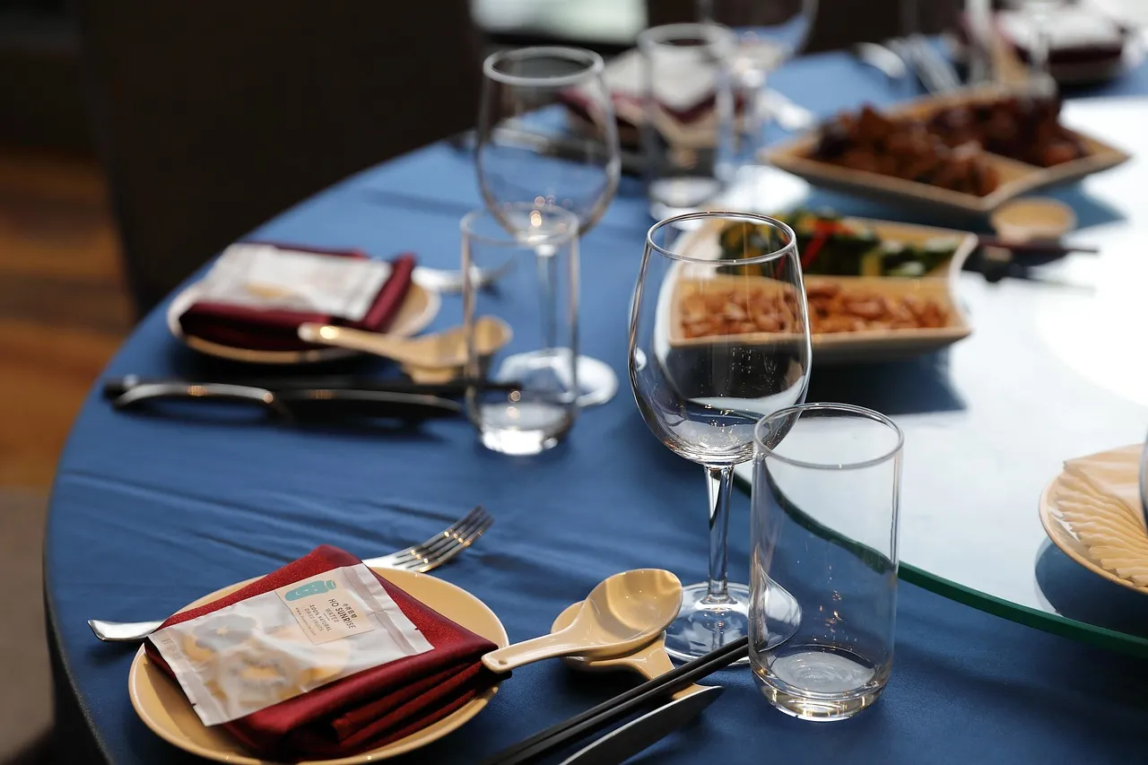 Photo showing table, table setting, cutlery and wine glasses.
