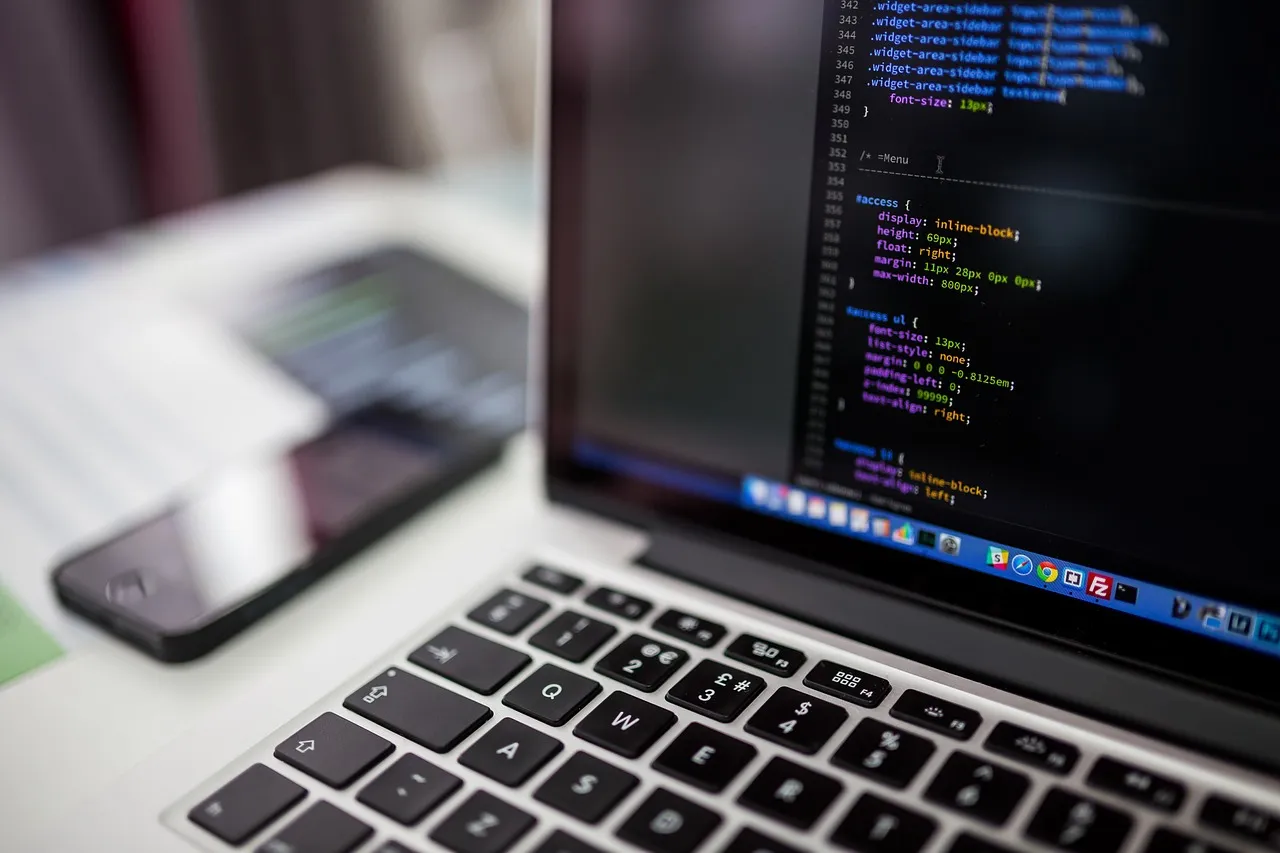 Photo showing laptop, macbook and codes.