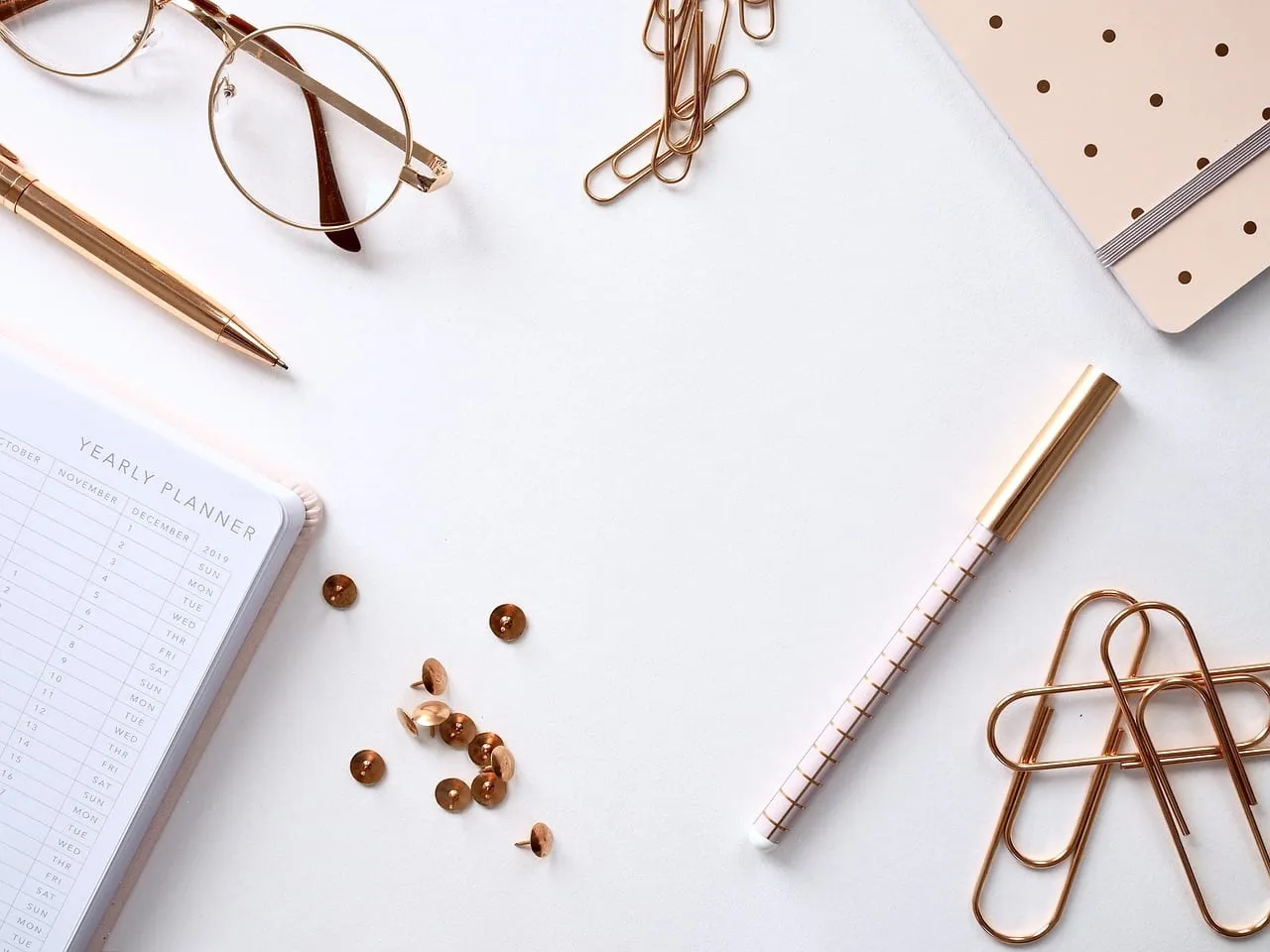 Photo showing notebook, desk, paper and desktop.