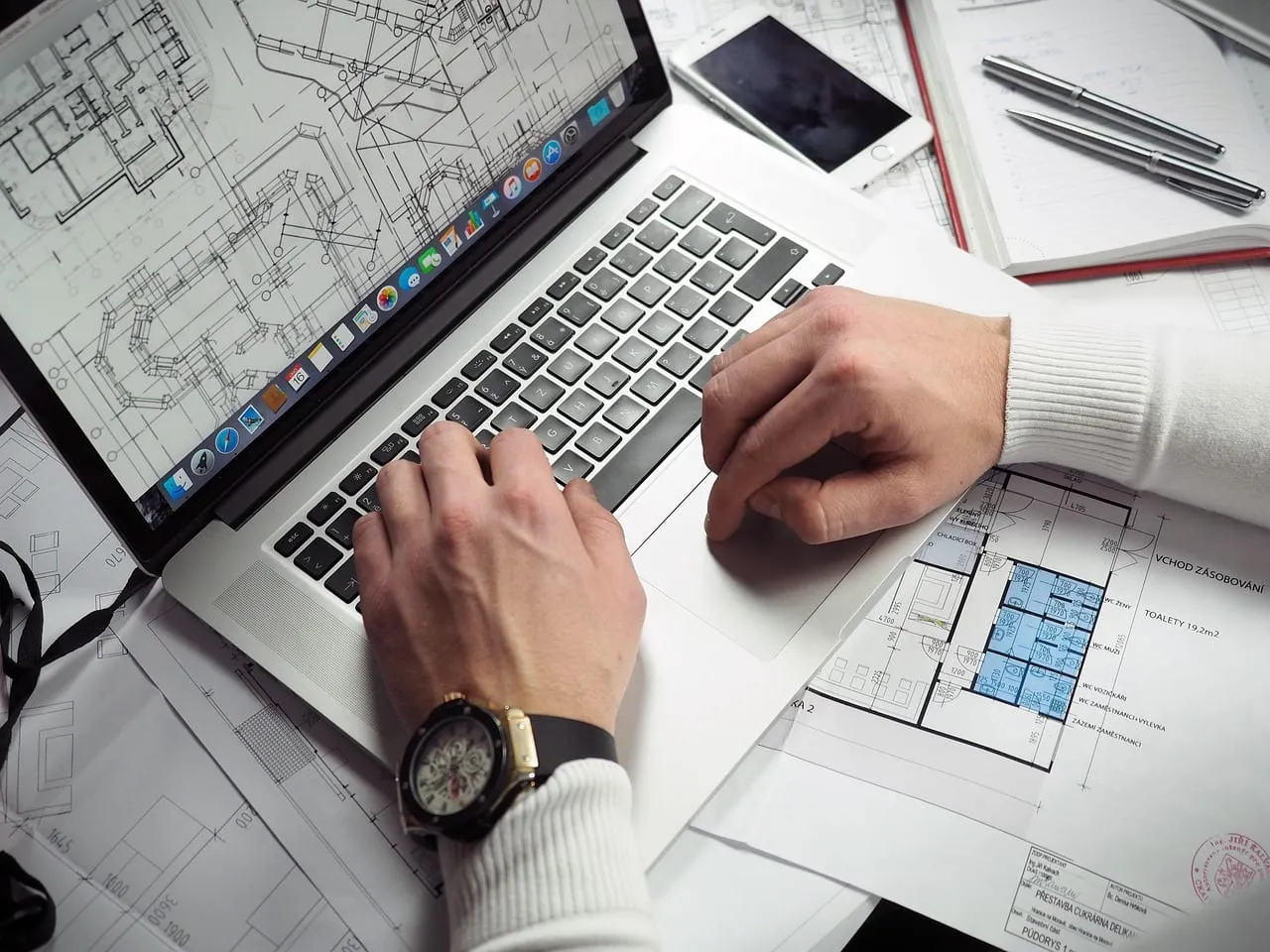 Photo showing blueprints, entrepreneur and hands.